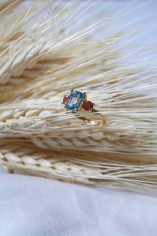 Anillo Uxia Topacio Azul y Granates cubierta en Oro